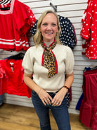 Ecru puff sleeve knit top styled with detachable leopard print red-trimmed neck scarf