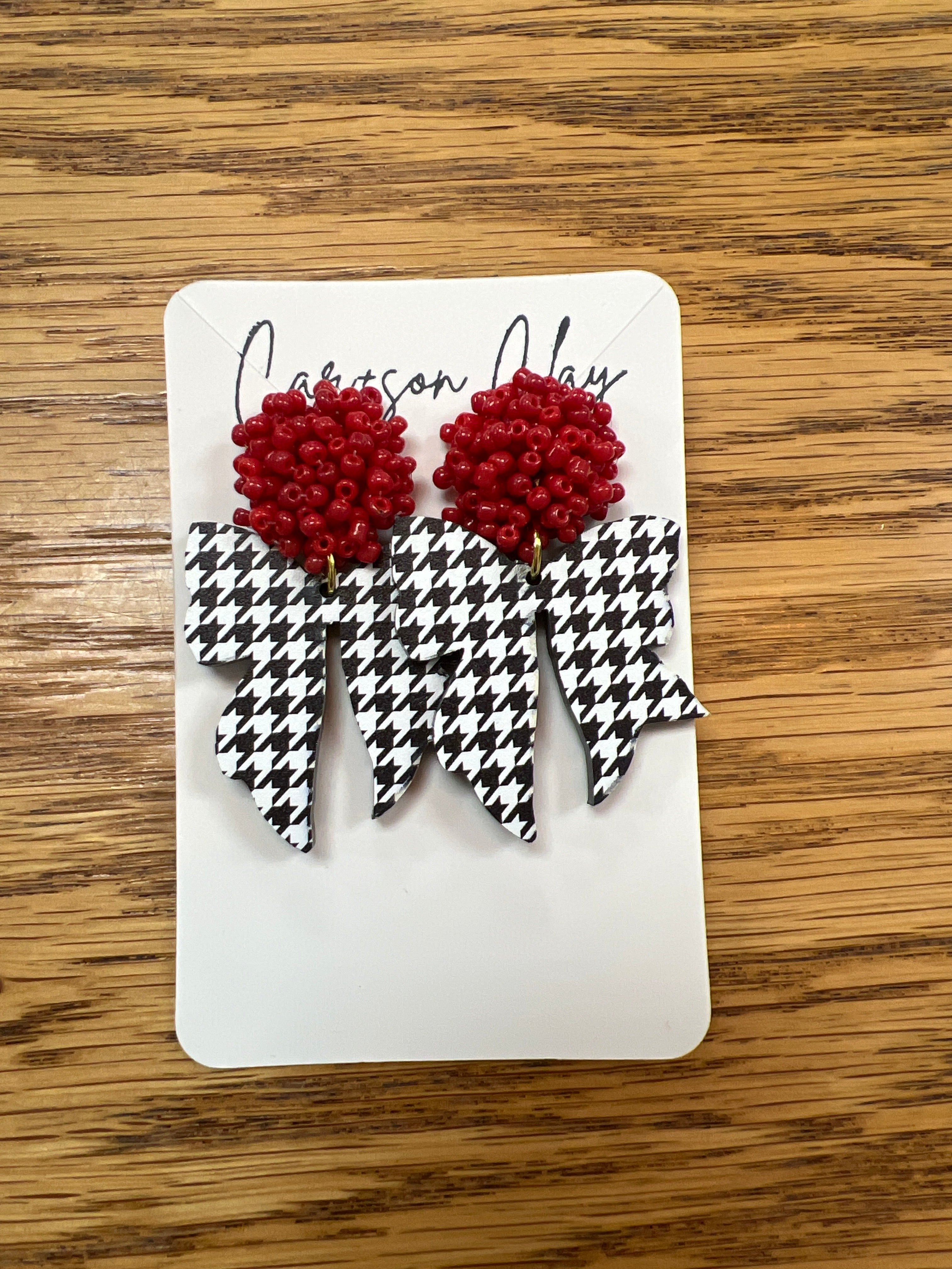 Red seed bead and black white houndstooth bow dangle earrings on display card