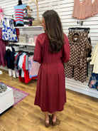 Burgundy long sleeve midi dress with flowy skirt, back view, by Entro