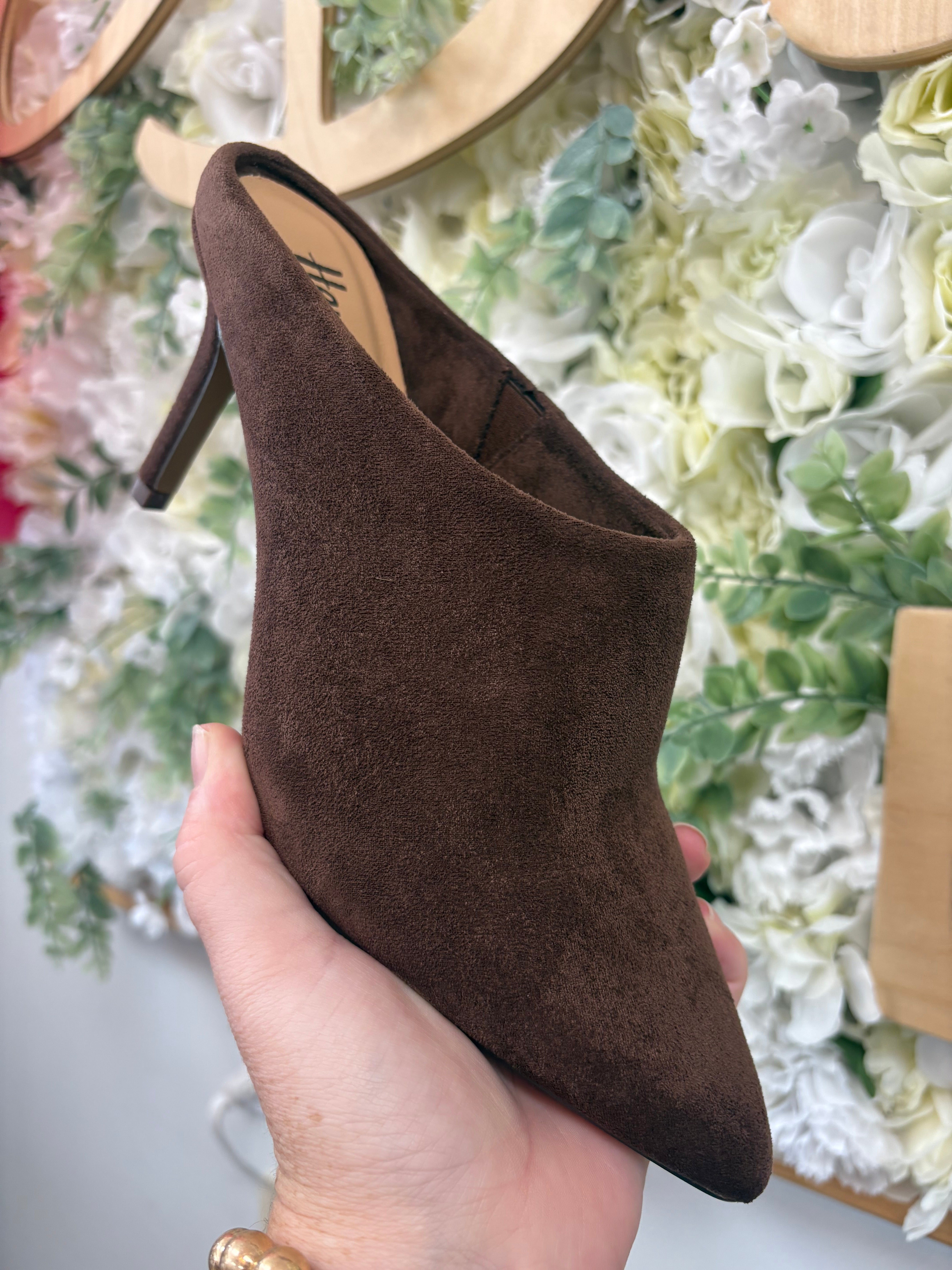 Corkys chocolate brown suede pointed-toe stiletto mule heel held by hand