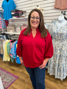 Wine red V-neck top with 3/4 balloon sleeves, worn with blue jeans