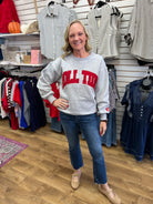 Grey crewneck sweatshirt with red Roll Tide lettering, worn with blue jeans