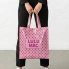 Light pink polka dot reusable tote bag with Lulu Mac branding and shoulder straps