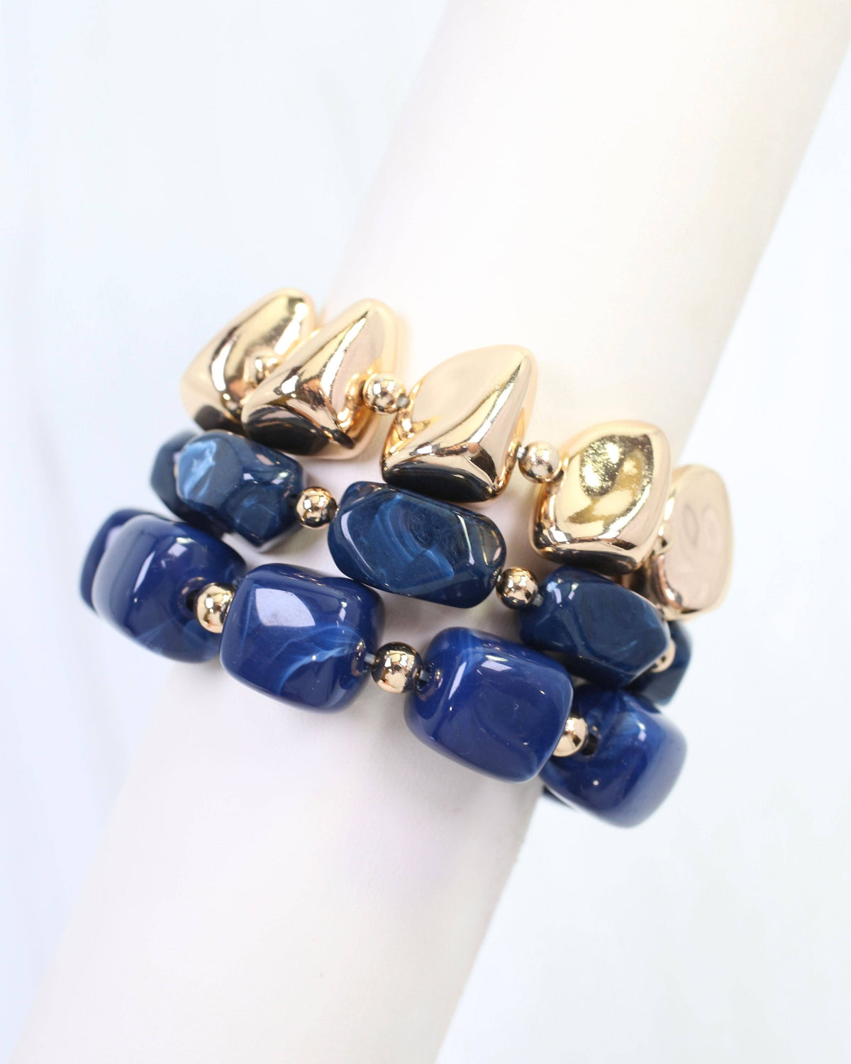 Navy blue beaded bracelet set with gold nugget and chunk beads on display stand