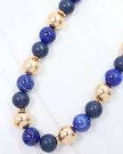 Navy and gold beaded ball necklace with matte, glossy, and textured round beads