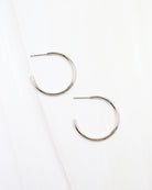 Caroline Hill Mayor thin silver hoop earrings with post backs on white marble